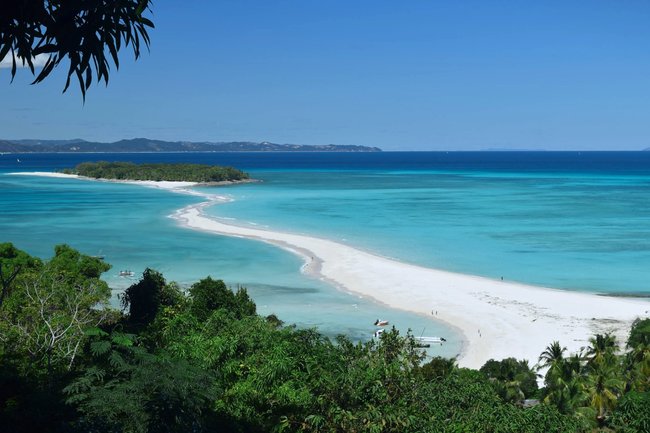 Photo of a white sandy beach sandbar between islands surrounded by turquoise ocean in Nosy Iranja, Nosy Be, Madagascar