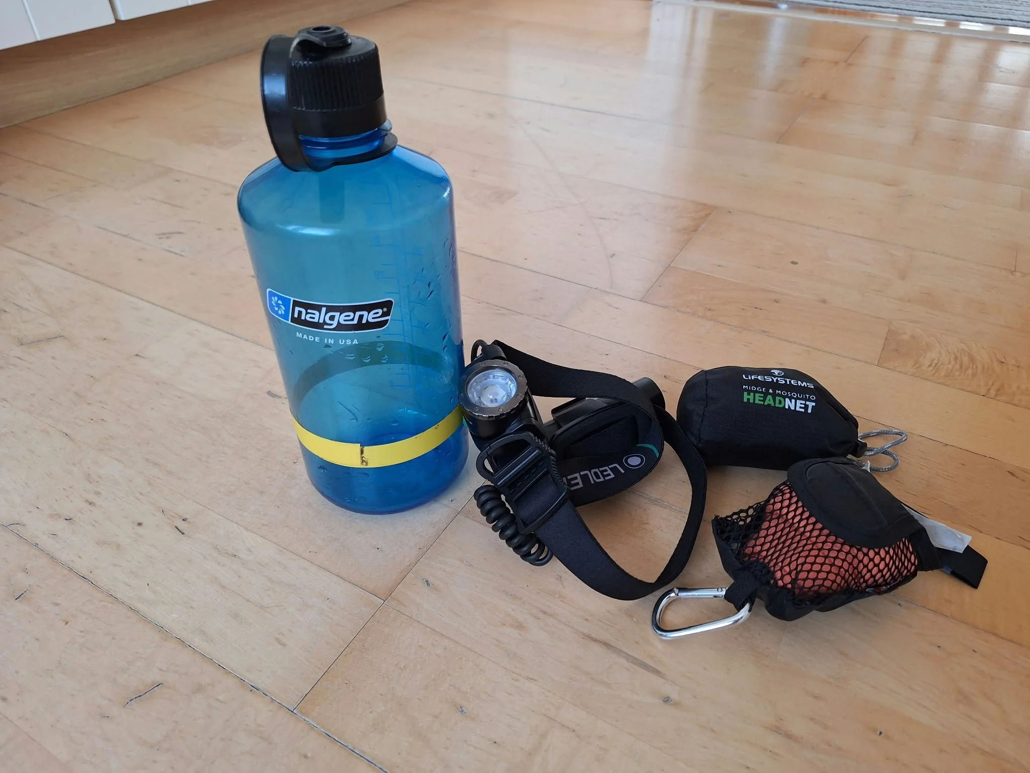 Nalgene water bottle, a headtorch, small towel and a mosquito/midge head net