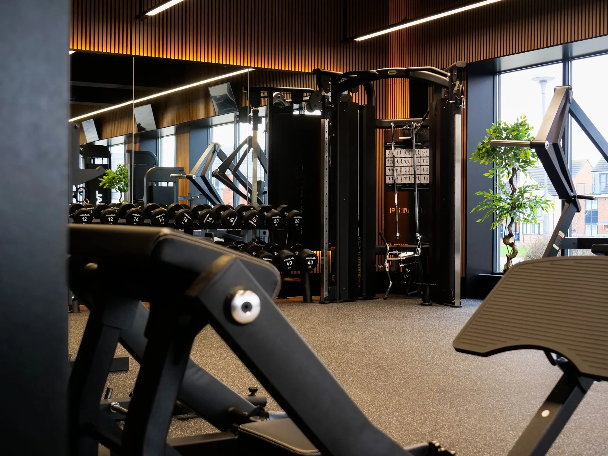 Adjustable bench and dumbbell rack on the gym floor at Physique Pro Great Park