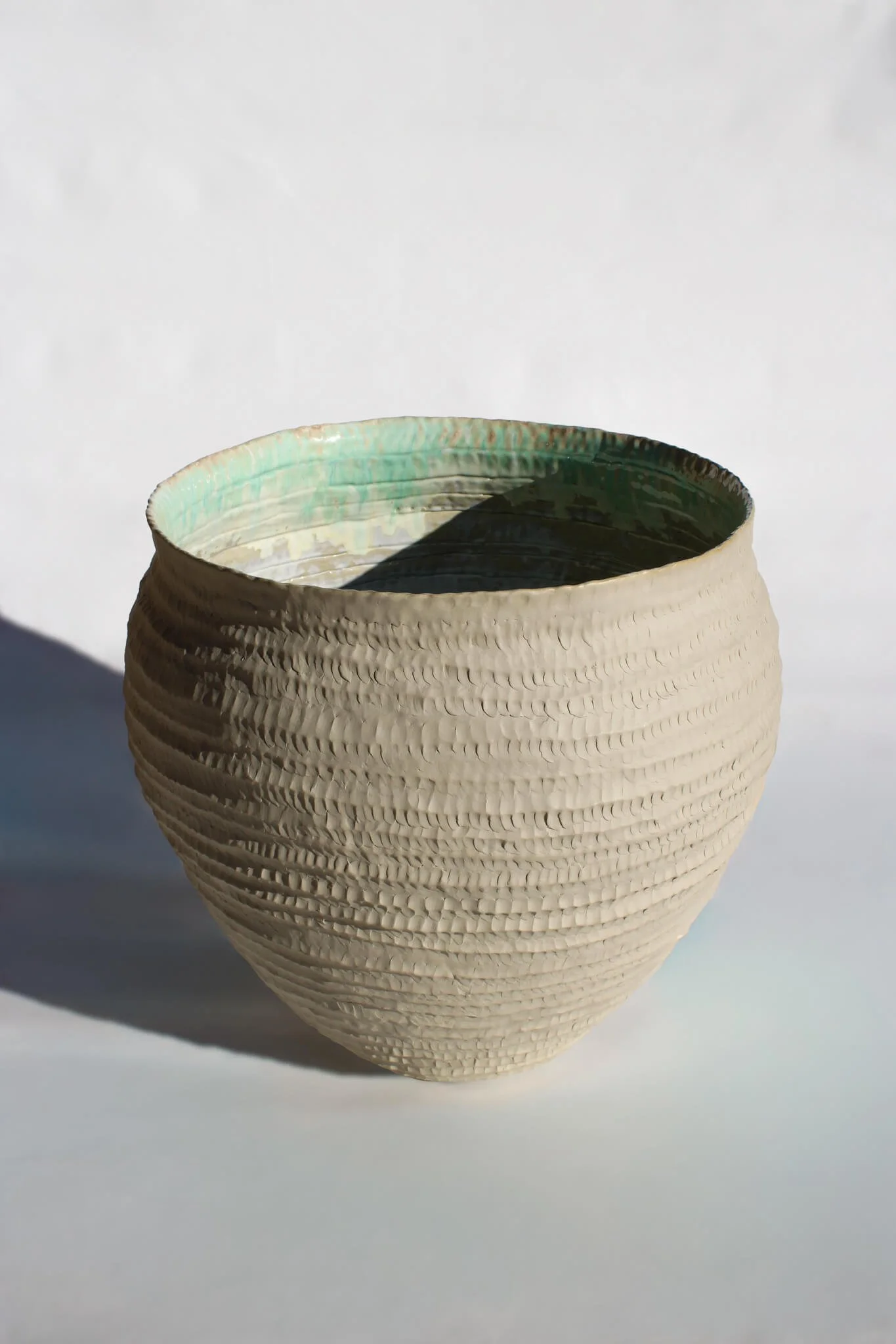 Full view of the Primordial Vessel: a giant ceramic vessel sculpted out of ivory stoneware clay and containing crystalline glaze by multidisciplinary artist Noemie Marmara