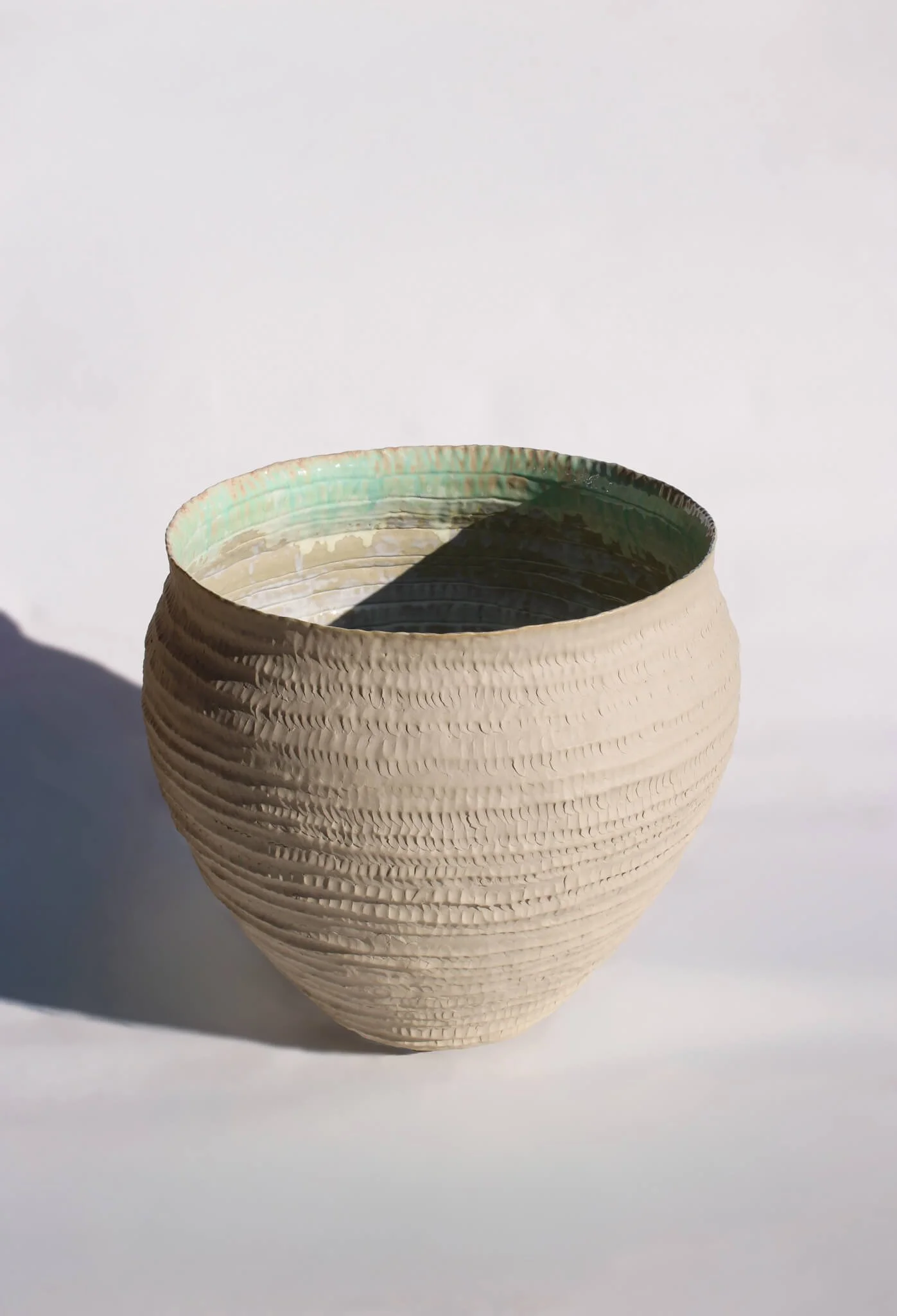 Full view of the Primordial Vessel: a giant ceramic vessel sculpted out of ivory stoneware clay and containing crystalline glaze by multidisciplinary artist Noemie Marmara