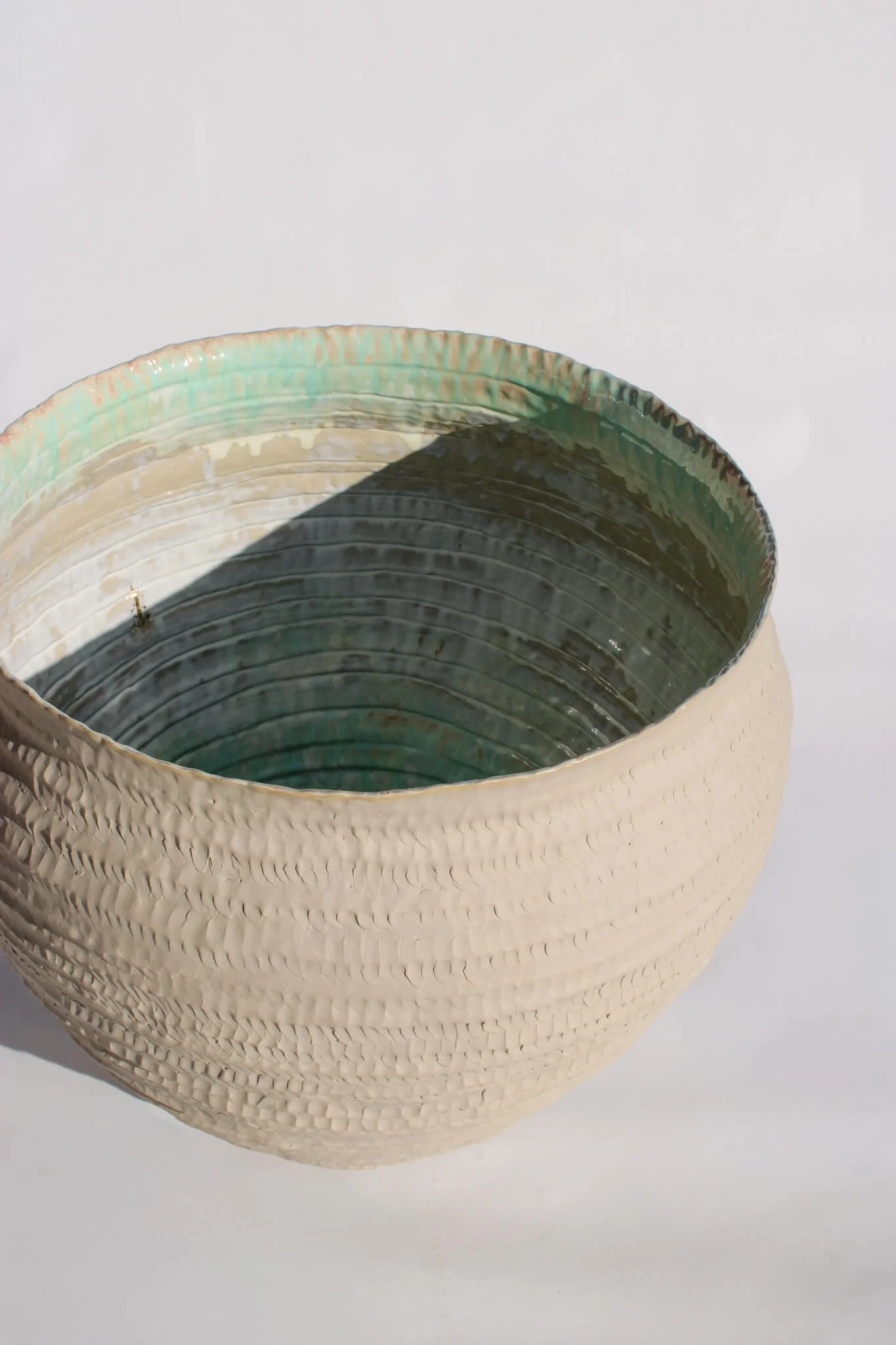 View from above of the Primordial Vessel: a giant ceramic vessel sculpted out of ivory stoneware clay and containing crystalline glaze by multidisciplinary artist Noemie Marmara