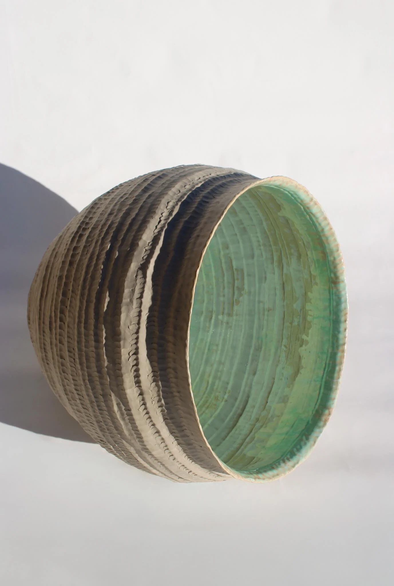 Side view of the reclined  Primordial Vessel: a giant stoneware ceramic vessel sculpted by multidisciplinary artist Noemie Marmara