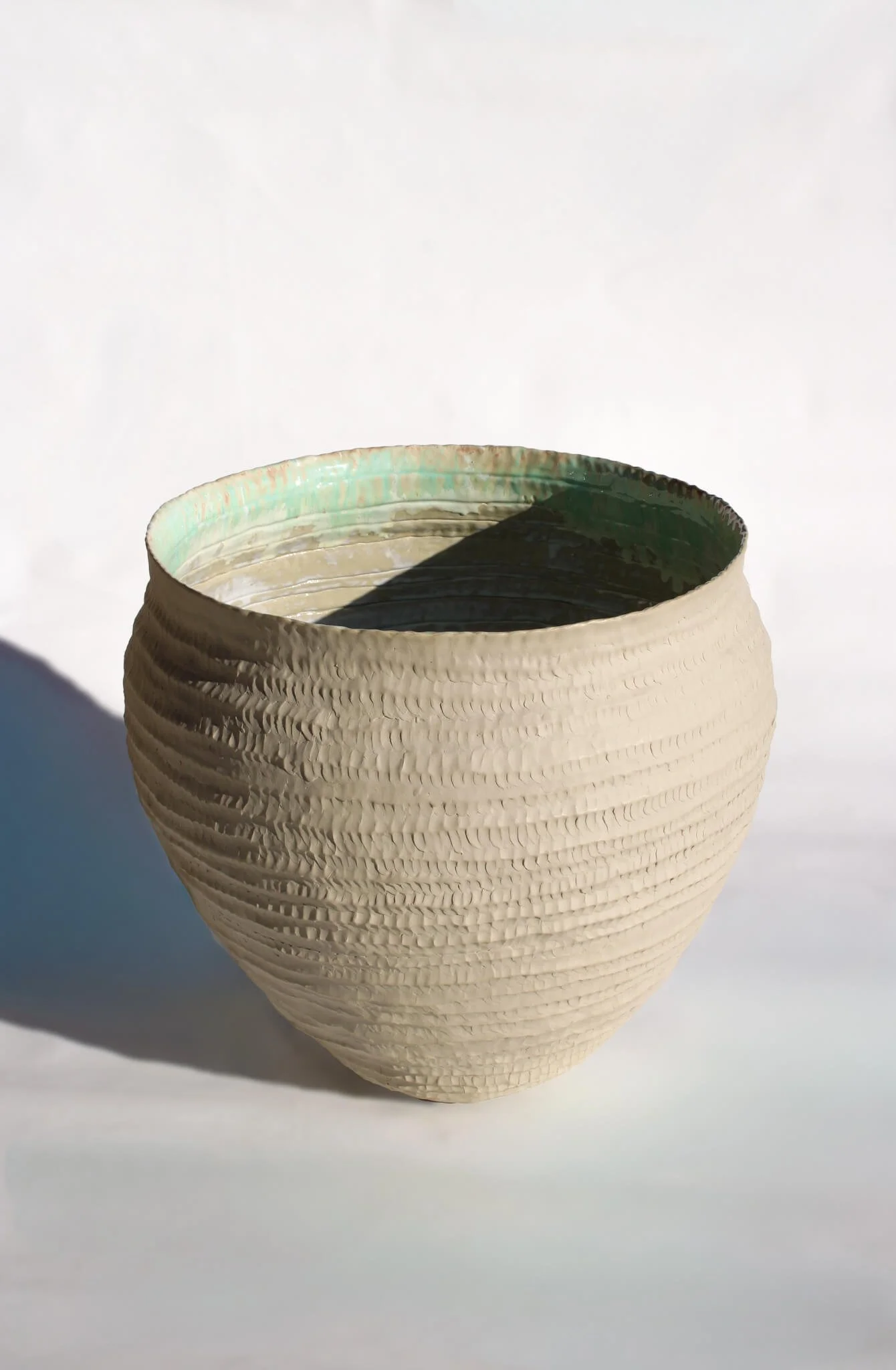 Full view of the Primordial Vessel: a giant ceramic vessel sculpted out of ivory stoneware clay and containing crystalline glaze by multidisciplinary artist Noemie Marmara