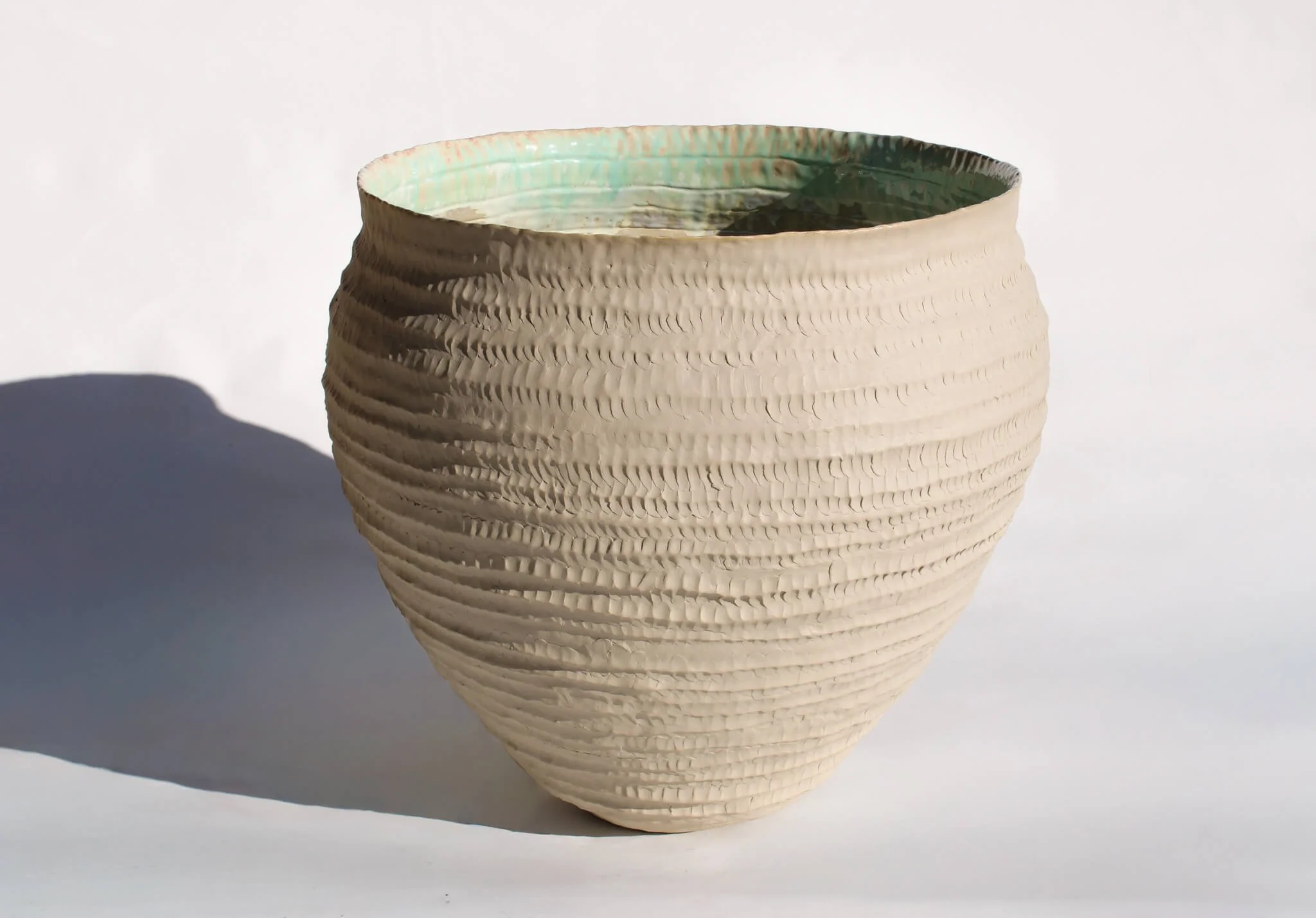 Full view of the Primordial Vessel: a giant ceramic vessel sculpted out of ivory stoneware clay and containing crystalline glaze by multidisciplinary artist Noemie Marmara