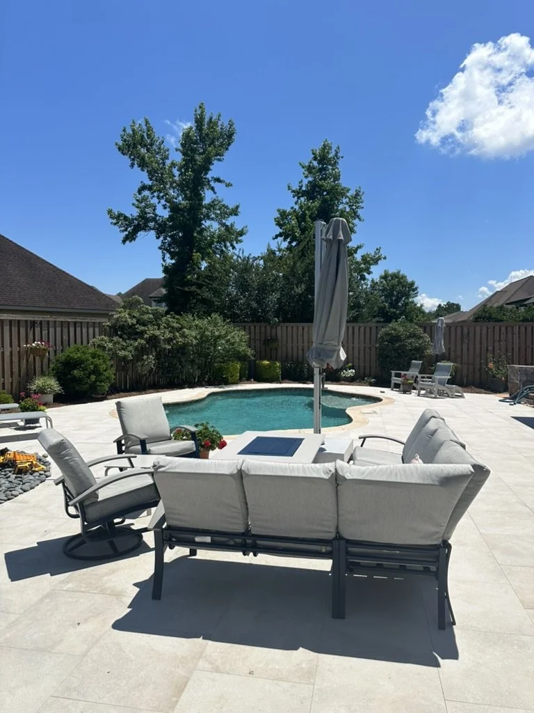 Stylish backyard patio with cozy furniture, pool, and beautifully landscaped private retreat.