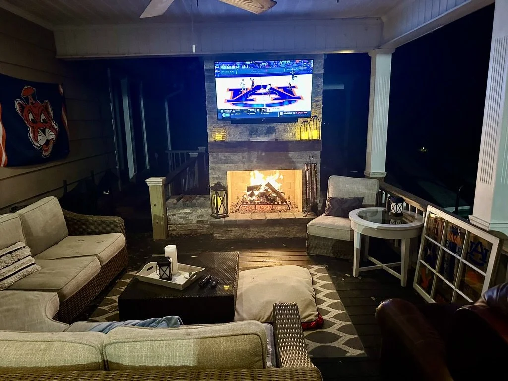 nviting outdoor lounge with fireplace, TV, and comfortable seating for entertainment.