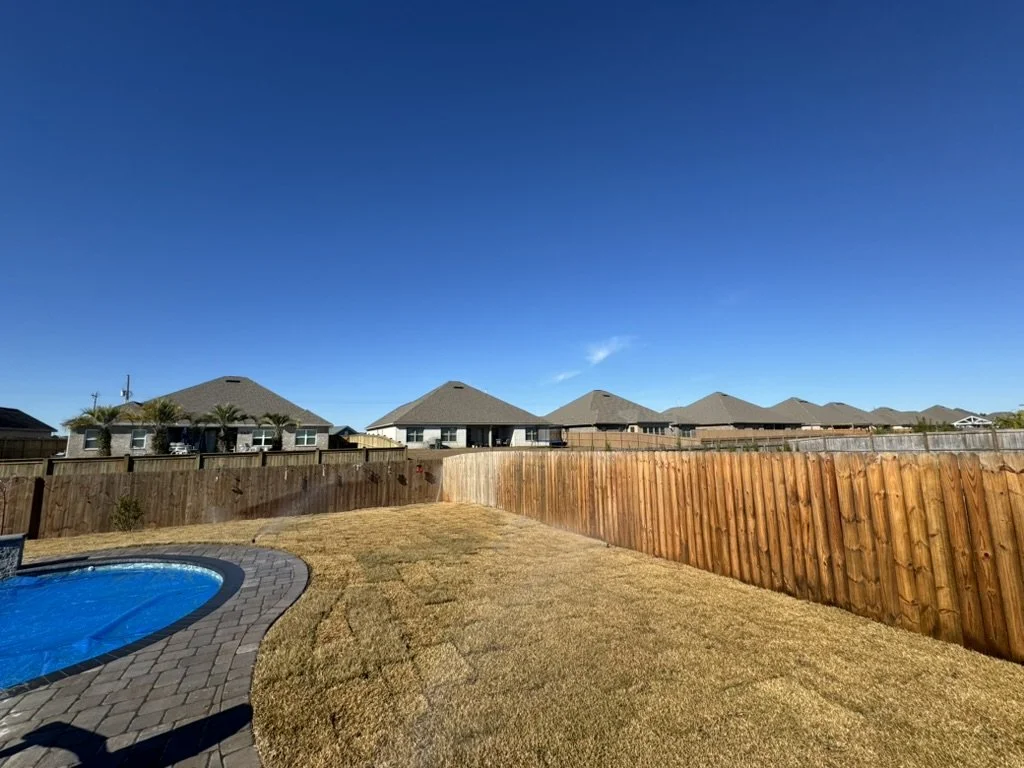 Spacious backyard with fresh sod, wooden fence, and inviting suburban poolside setting.
