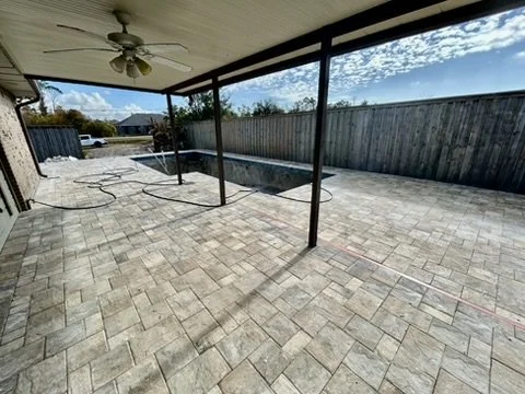 Spacious covered patio with elegant pavers, ideal for outdoor gatherings and shaded relaxation.