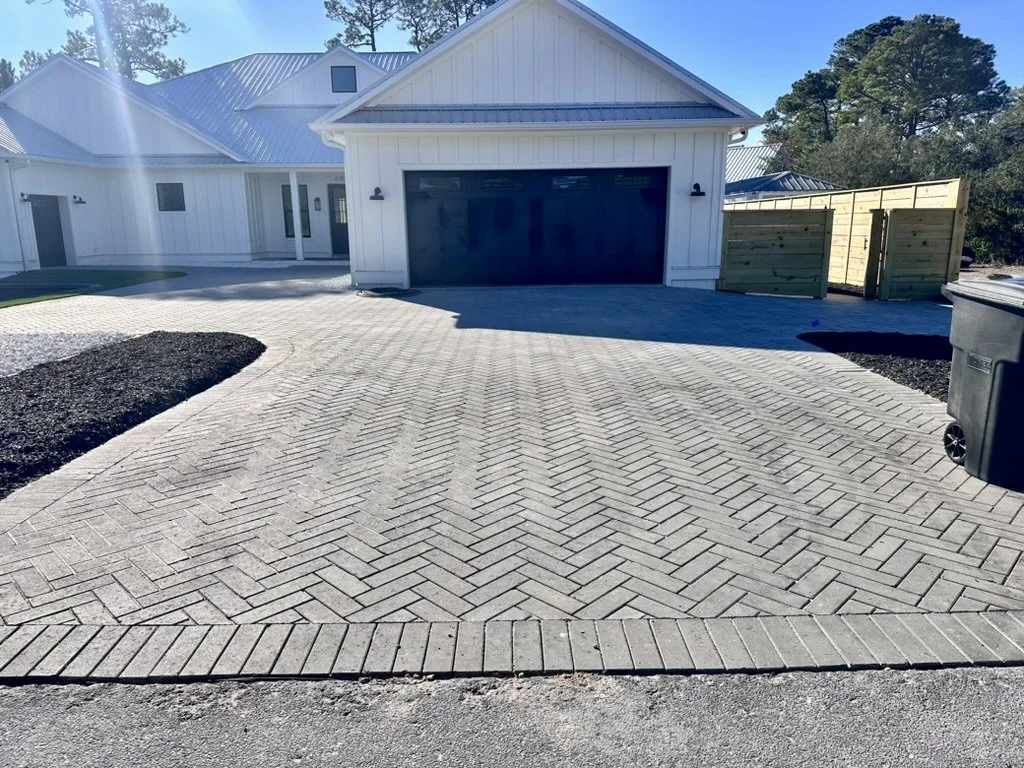 Modern herringbone paver driveway enhancing the curb appeal of a pristine home.