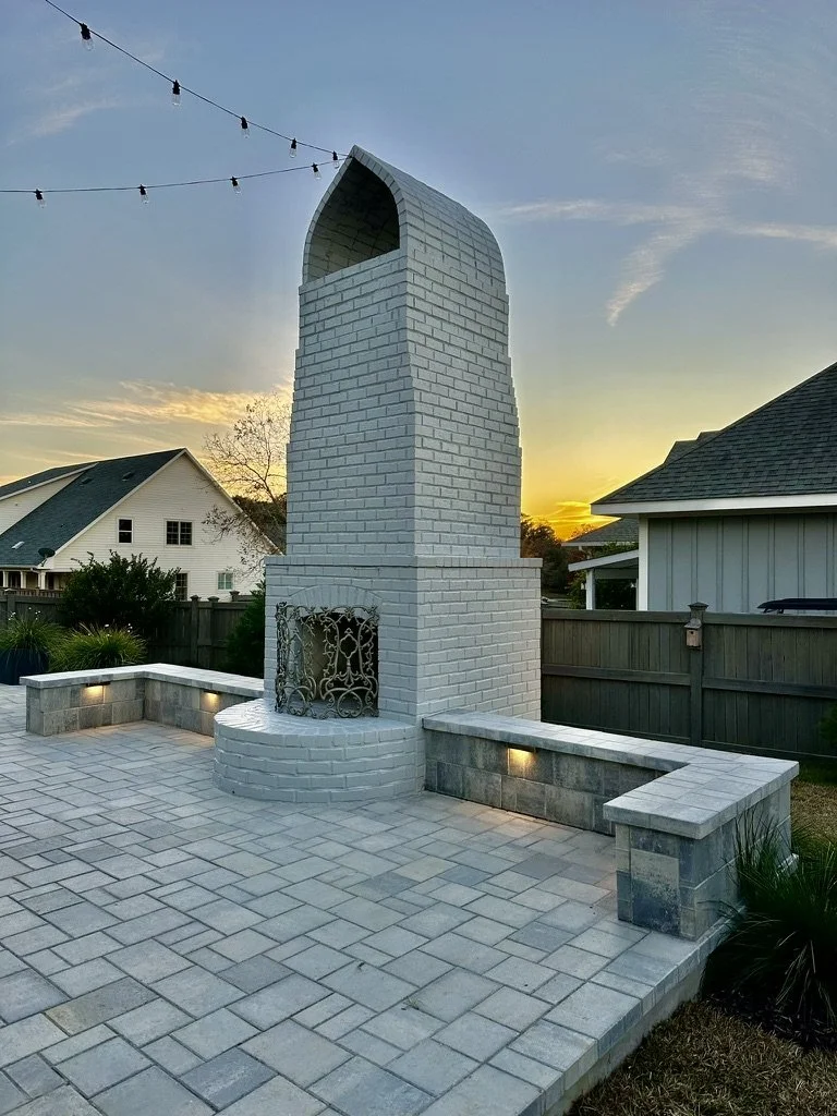 Unique white brick outdoor fireplace with built-in seating for family-friendly spaces.