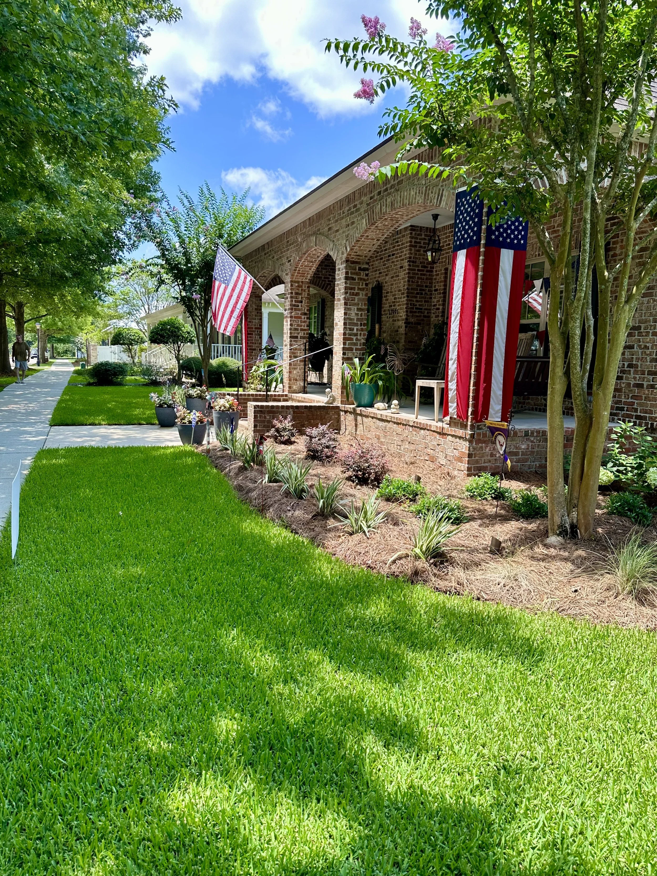 Southern home with landscaped front yard and American flags displayed