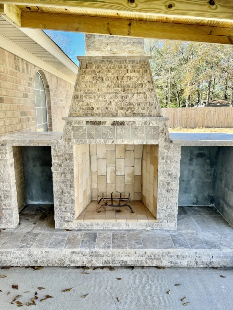 Custom stone outdoor fireplace ready for hosting and relaxation.