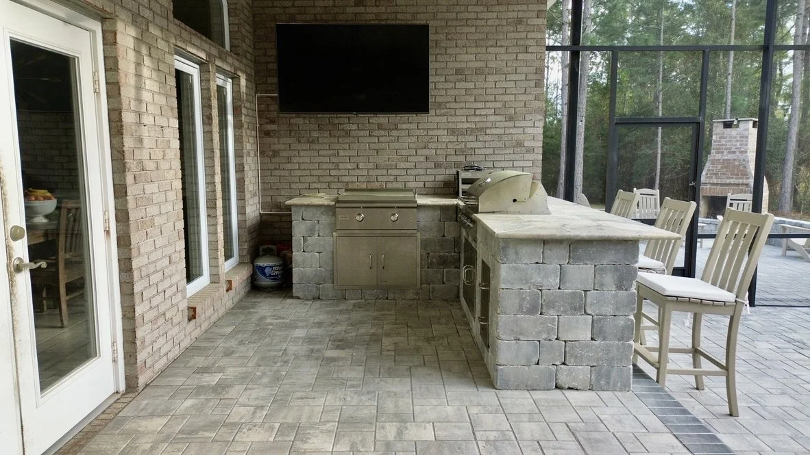 Modern covered outdoor kitchen featuring ample counter space and integrated grilling solutions.
