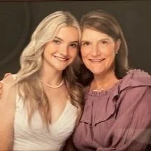 Two women smiling and posing closely together for a photo.