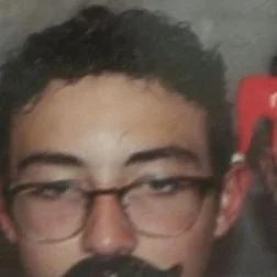 Close-up of a person with glasses and curly hair.