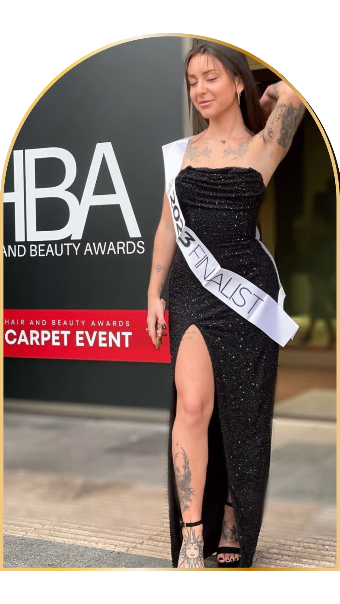 Woman in black evening gown with '2023 Finalist' sash at Hair and Beauty Awards event.