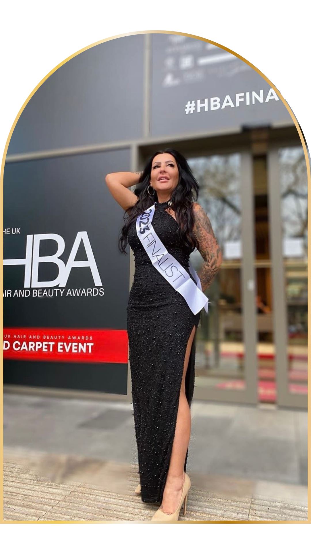 Woman in black dress with '2023 Finalist' sash at Hair and Beauty Awards event.