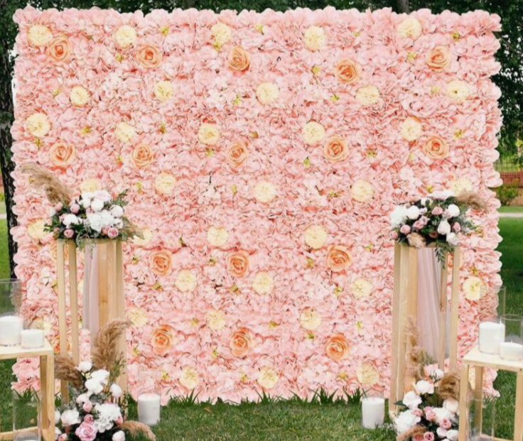 A wall decorated with a dense arrangement of pink, light pink, and white roses.