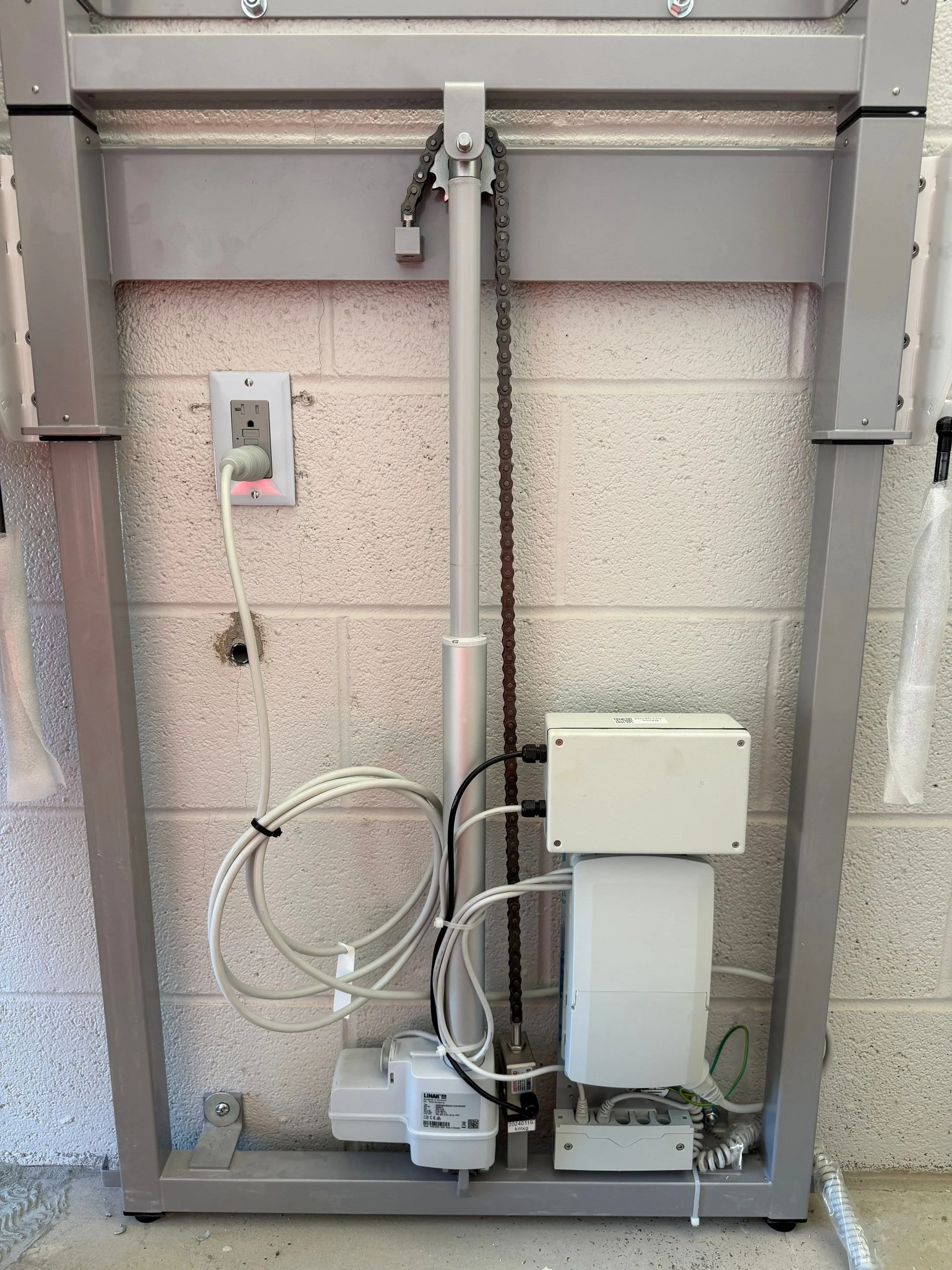 The inner components of a powered changing table mounted to a wall. 
