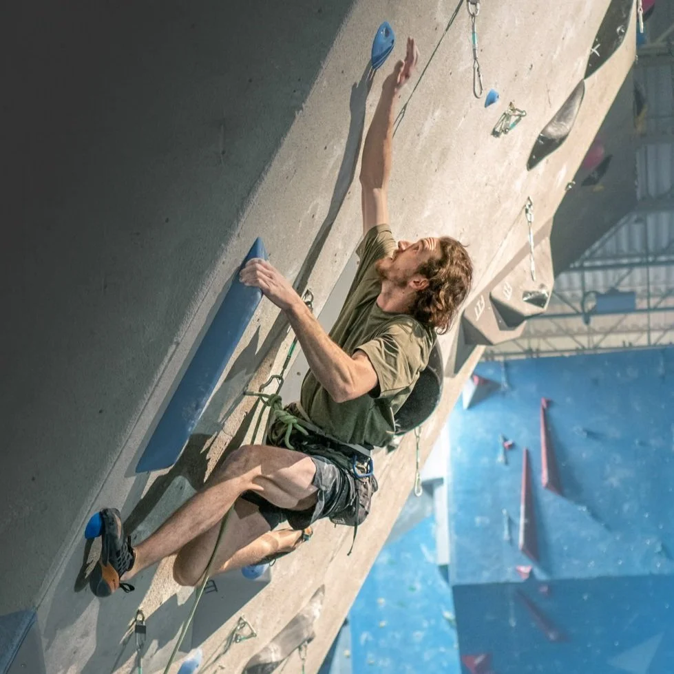 Grimpeur en premier de cordée sur un mur  déversant au Crux Boisbriand