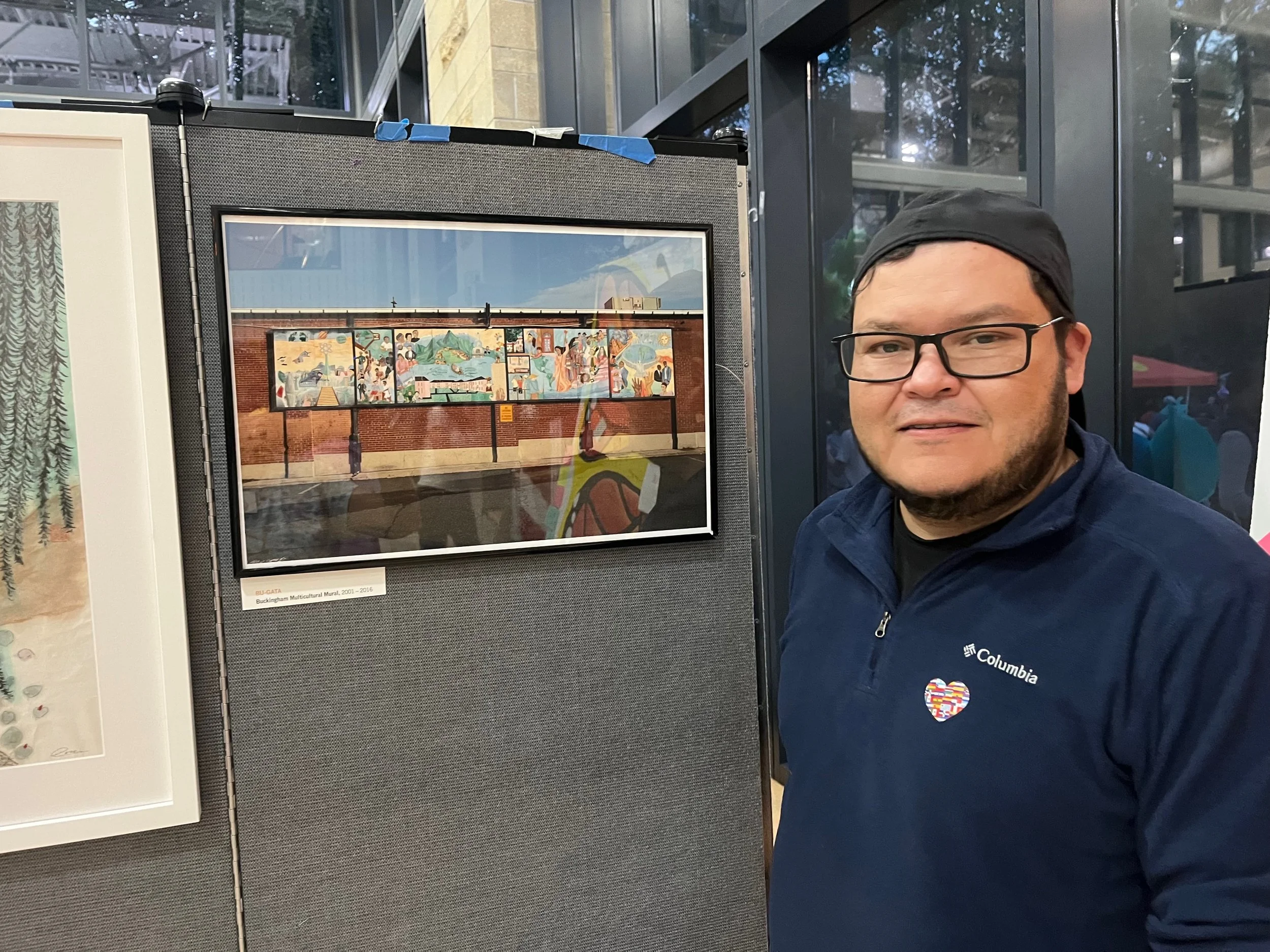 Saul Reyes sees the photo of the Buckingham Multicultural Mural in the exhibit