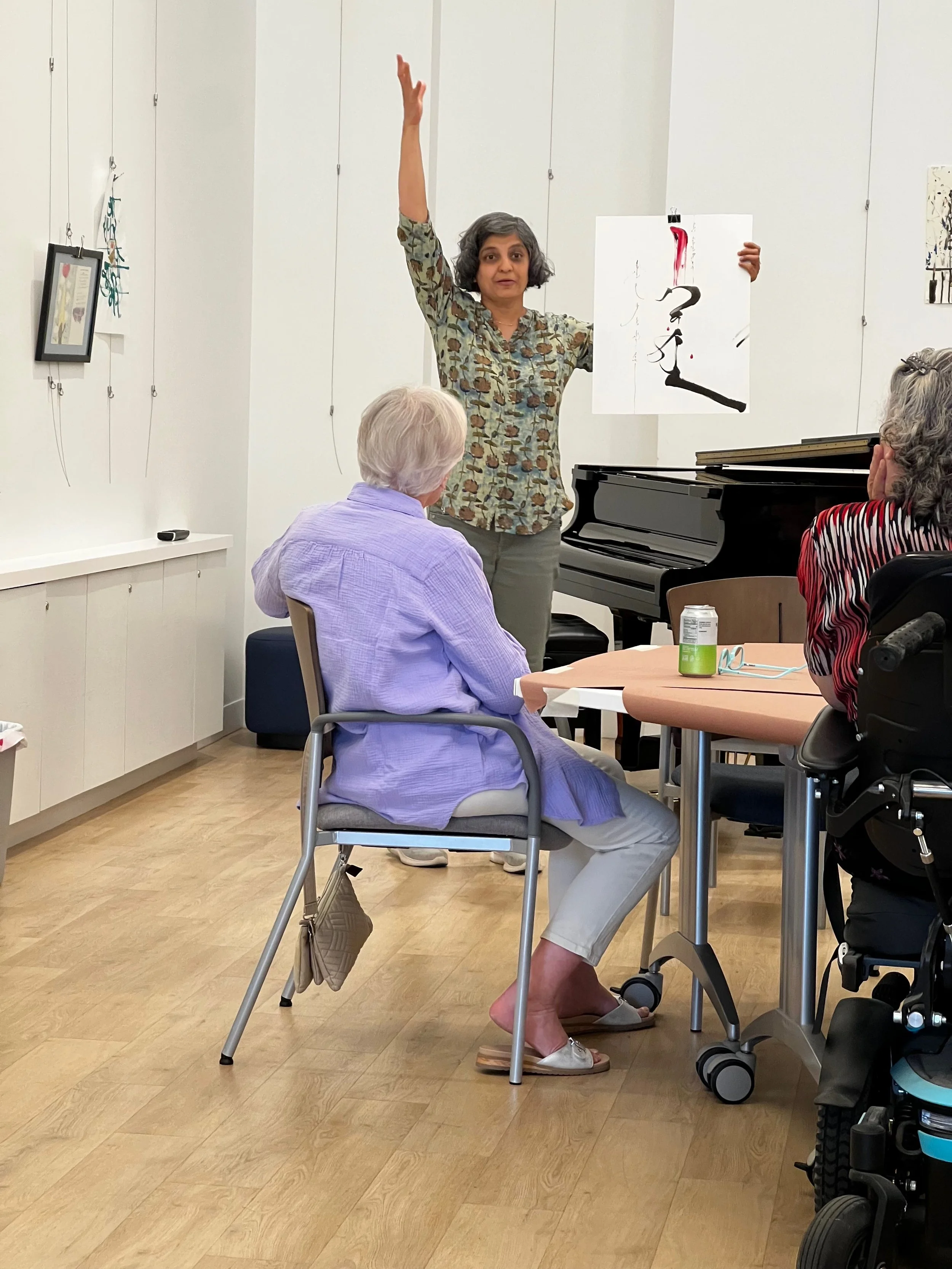 Sushmita shares about an artwork by Mongolian musician Uyanga who showed her a video of a performance. She wore a tall red hat of Mongolian empresses in the video. Sushmita invited her to add that to her calligraphy and she did.