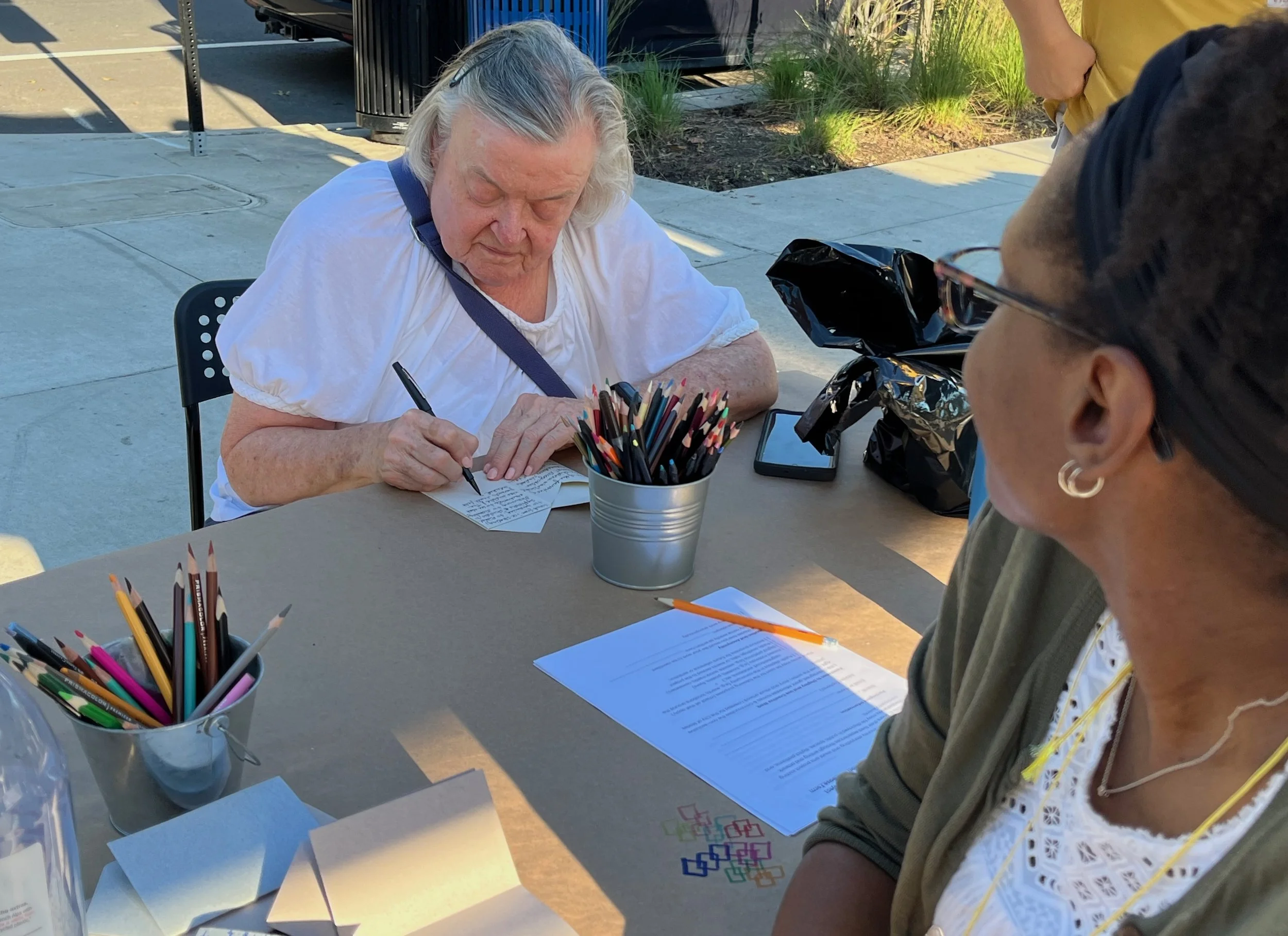 Studio PAUSE's Kori Johnson engages with a visitor who shares her story