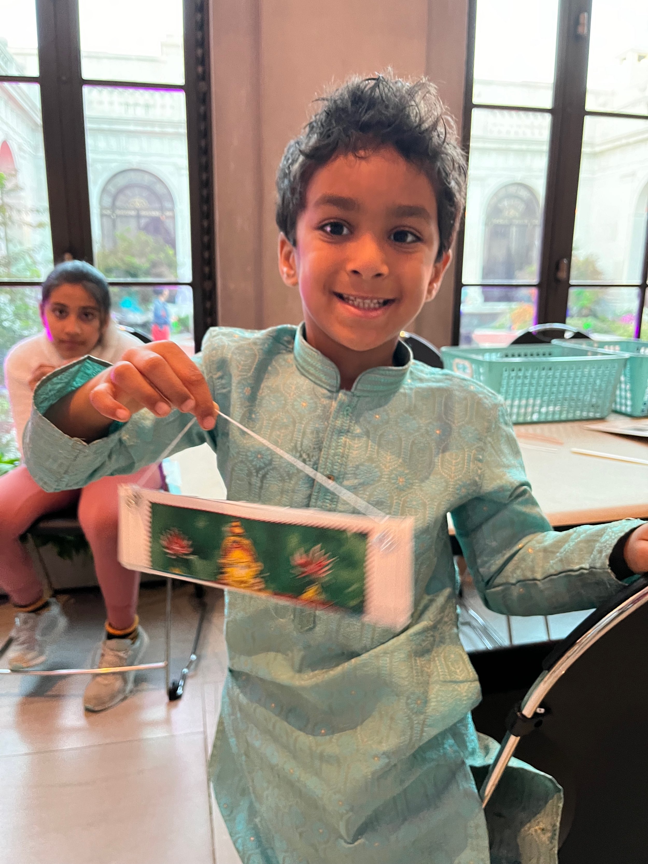 Young participant in his Indian clothes and with his folded up book