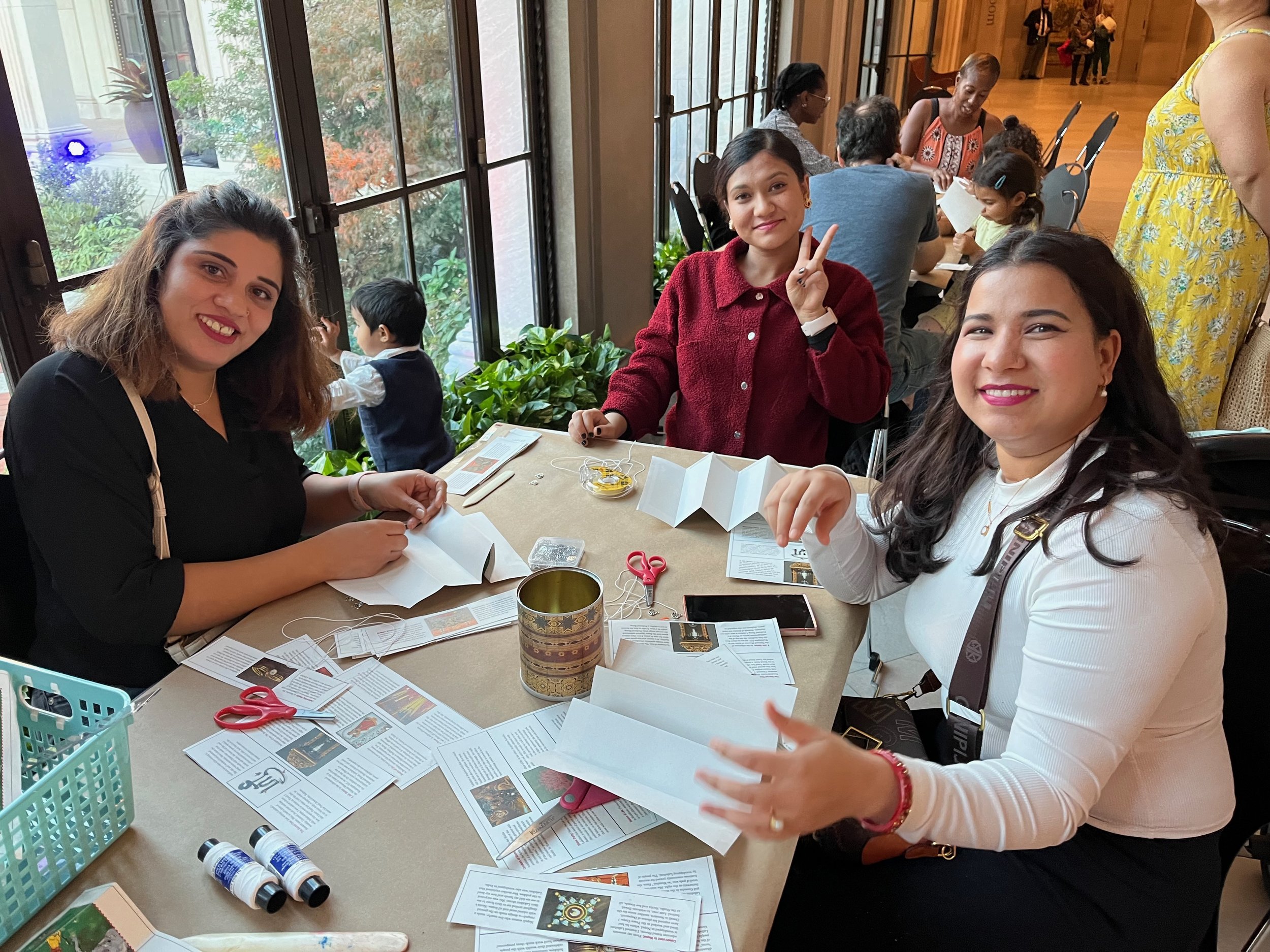 From left, Sarita, Deelasha, and Usha, make their books at the museum