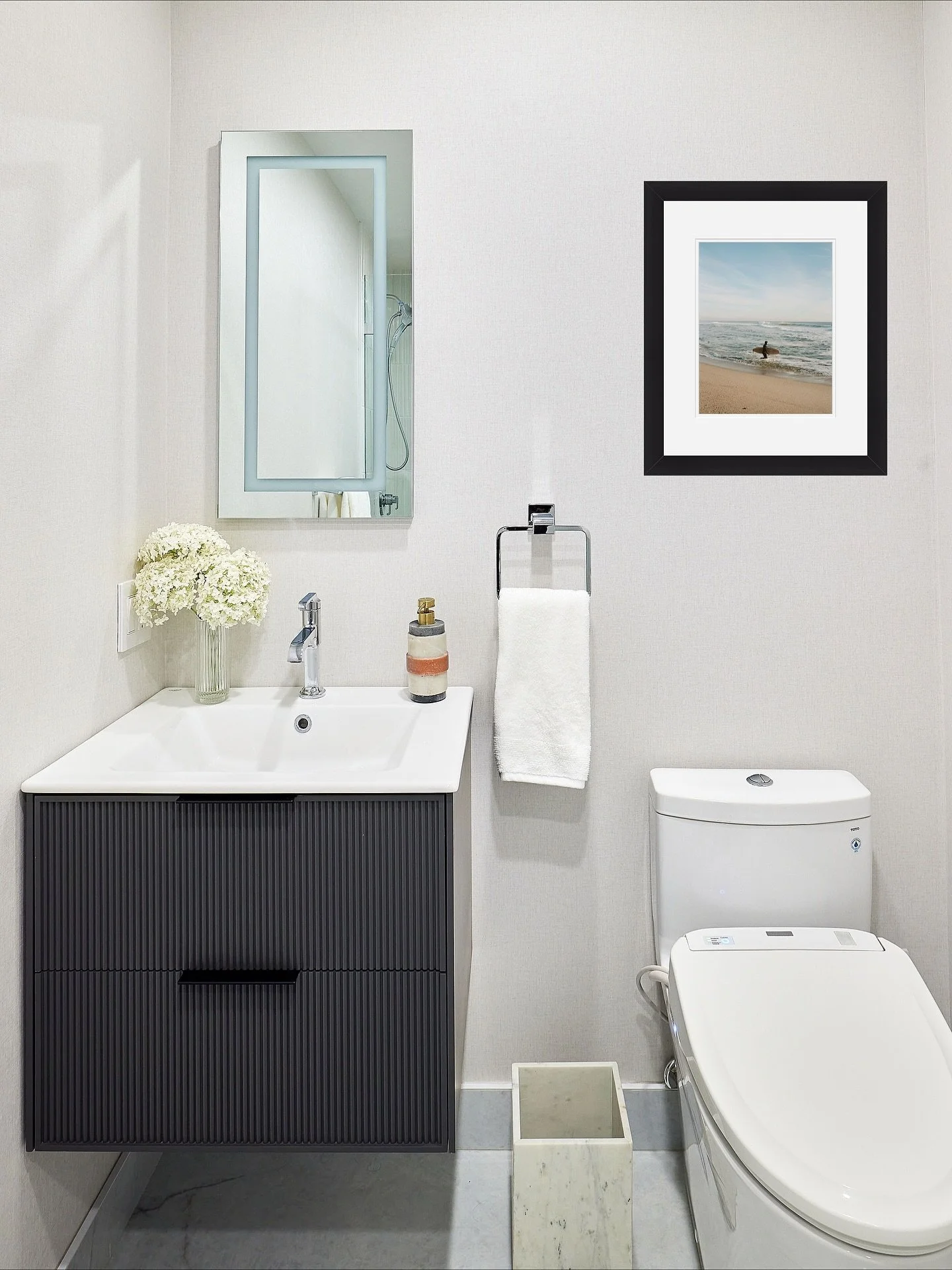 We didn&rsquo;t need to move any plumbing to still create a big impact with this basement bathroom remodel (swipe to see the before). Did you notice the subtle texture in the wallpaper? It is washable! and the beach scene art was taken by the talente