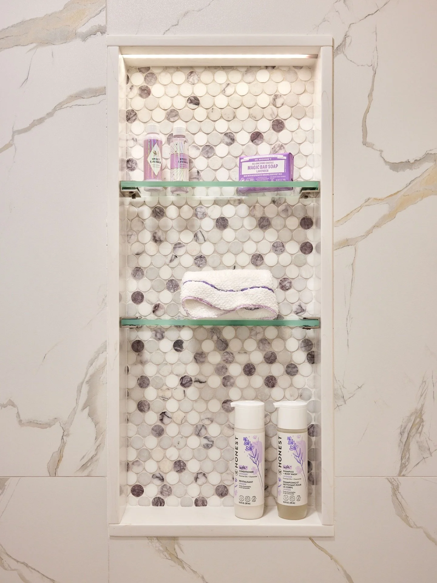 In person, the shimmer in the wall tiles is 👌🏼. We paired them with a Lilac Marble penny tile and polished nickel shower system. 
.
.
Design: @curate_interior_designs 
Photography: @juliadags 
Construction: @mchomeimprovements
