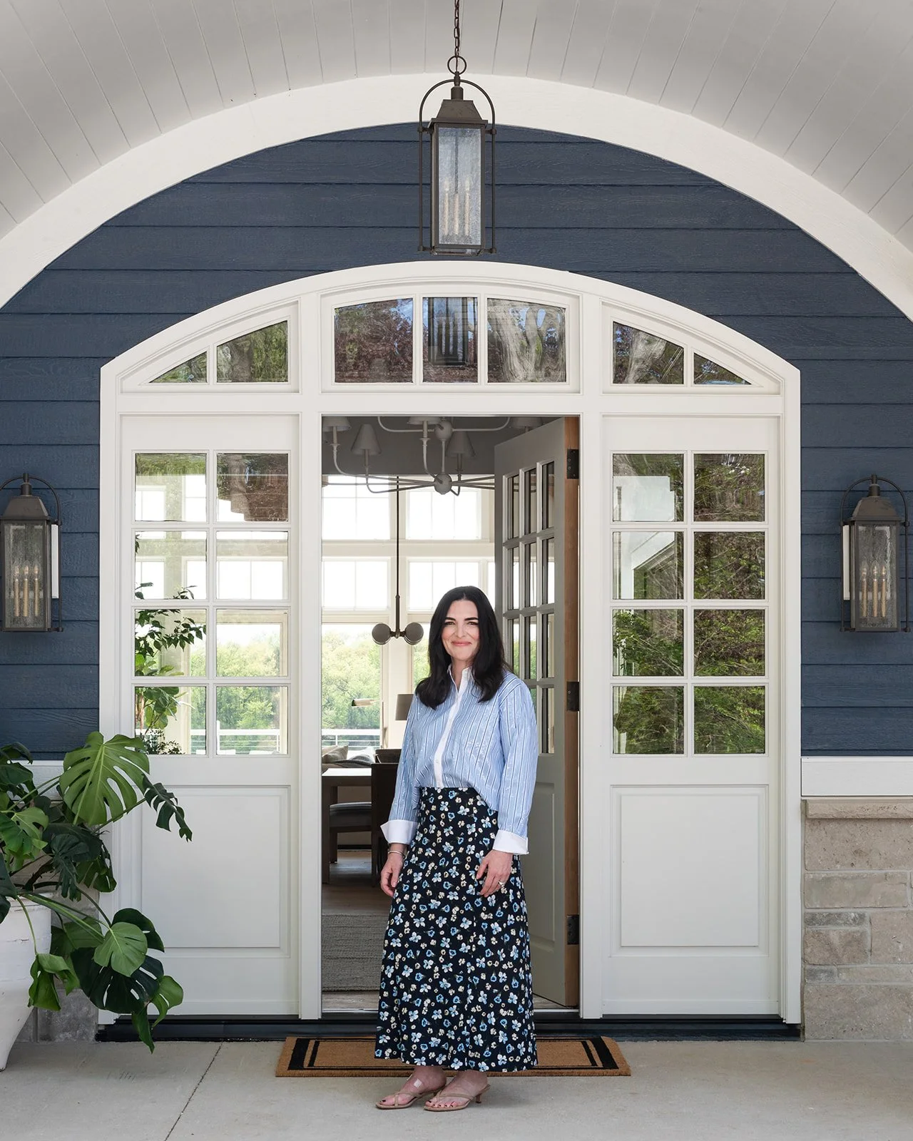 KED Interiors Principal, founder and head designer Katie Wozniak of Barrington, IL in front of a new custom home, interior design, blue vacation.
