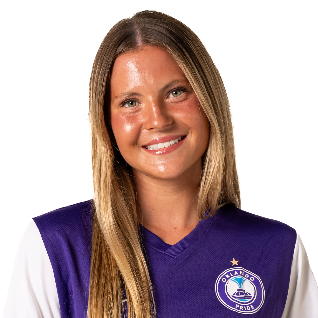 A young woman with long blonde hair smiling, wearing a purple sports jersey with 'Orlando Pride' logo.