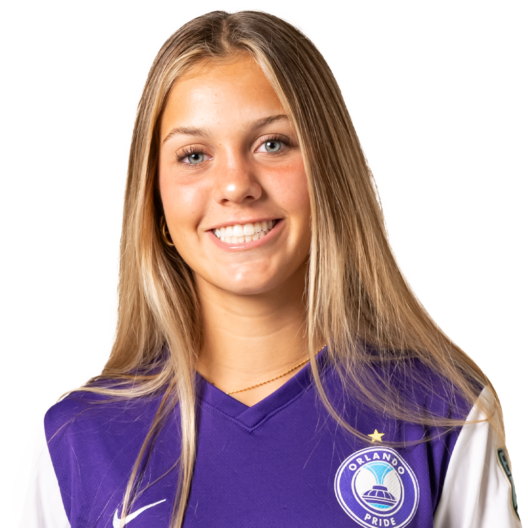 A smiling young woman with long blonde hair, wearing a purple Orlando Pride soccer jersey.