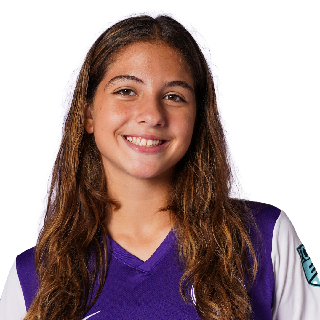 Portrait of a young woman with long, wavy brown hair, smiling, wearing a purple and white athletic jersey with a logo on the shoulder, against a black background with purple overlay.