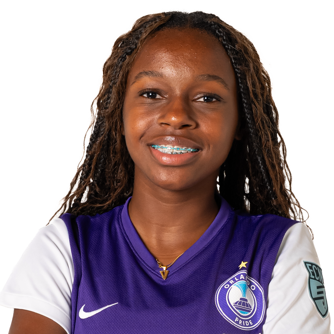Portrait of a young woman with braids wearing a purple and white Orlando Pride soccer jersey, smiling at the camera.