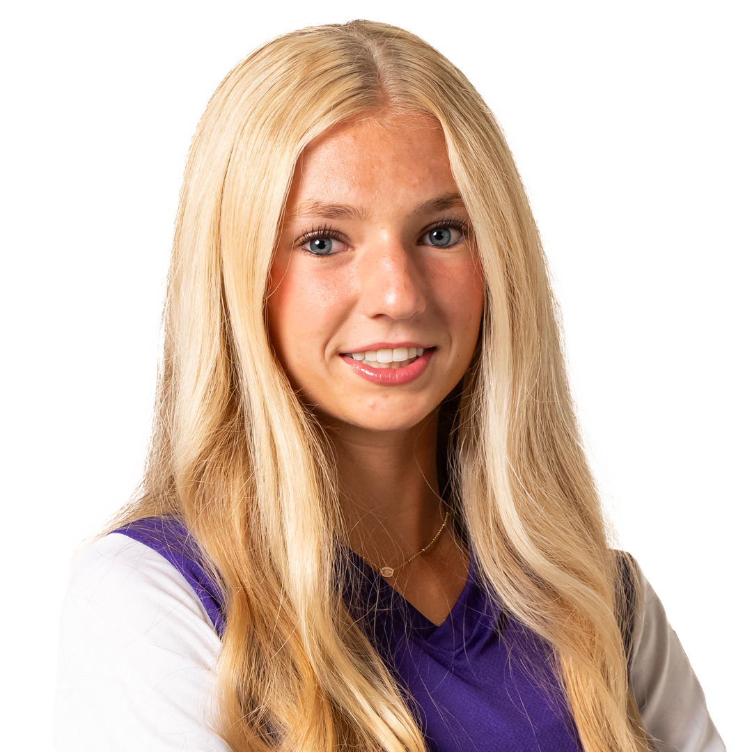 Portrait of a young woman with long blonde hair, blue eyes, and a friendly smile, wearing a purple and white sports jersey.