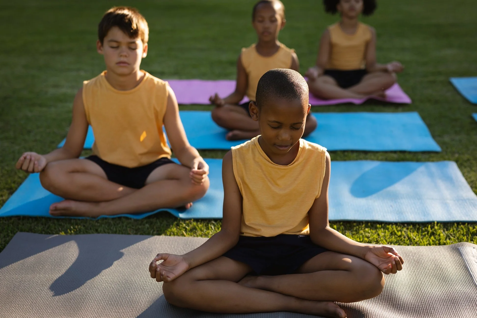 children meditating on lawn during vacation