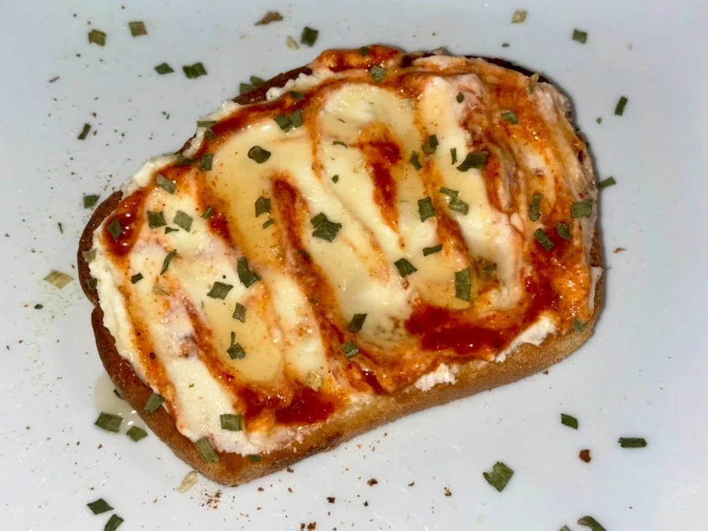 This is how I make Sriracha Ricotta toast when I want something comforting but not boring.

About &frac14; cup ricotta mixed with 1&ndash;2 teaspoons honey, a squeeze of lemon juice, garlic salt, and black pepper. 

Spread on toast, drizzle sriracha,