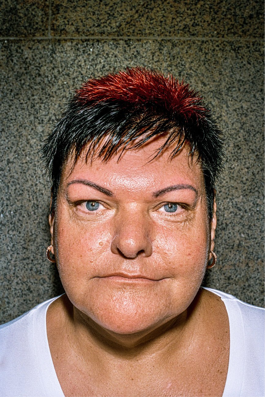 Retrato de uma mulher de cabelos curtos em dois tons, preto e vermelho.