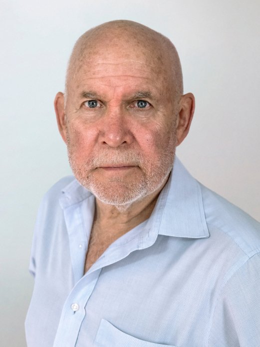 Der Kopf und Oberkörper von Steve McCurry, der ein blaues Hemd trägt, vor einem neutralen Hintergrund.