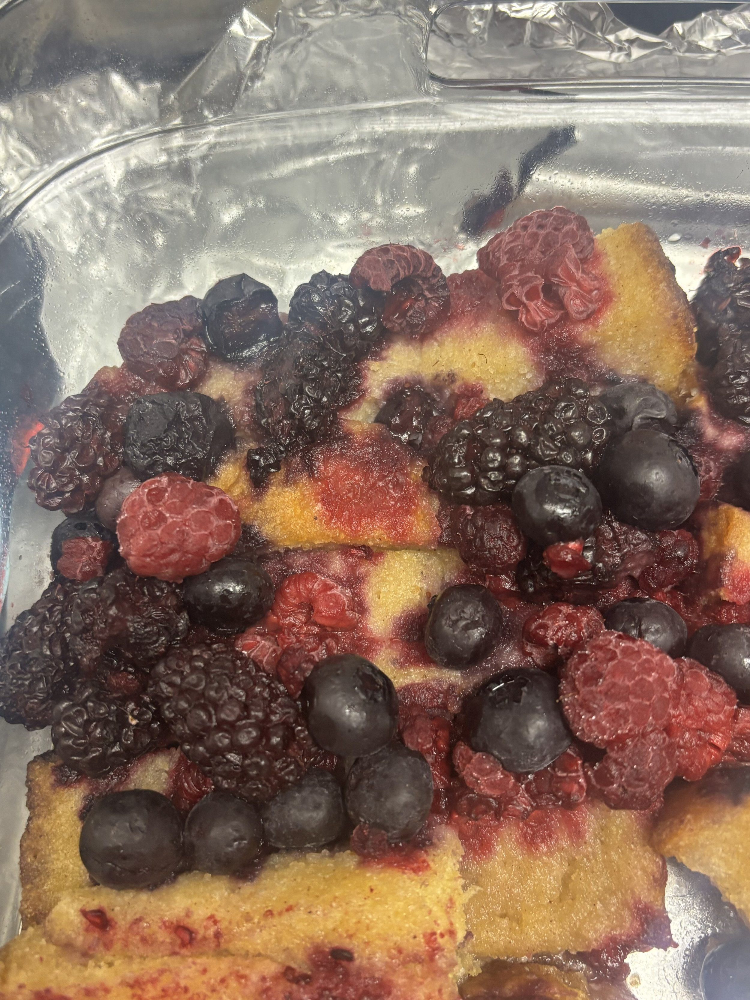  A close-up of a French toast casserole with blackberries, blueberries and raspberries is shown. 