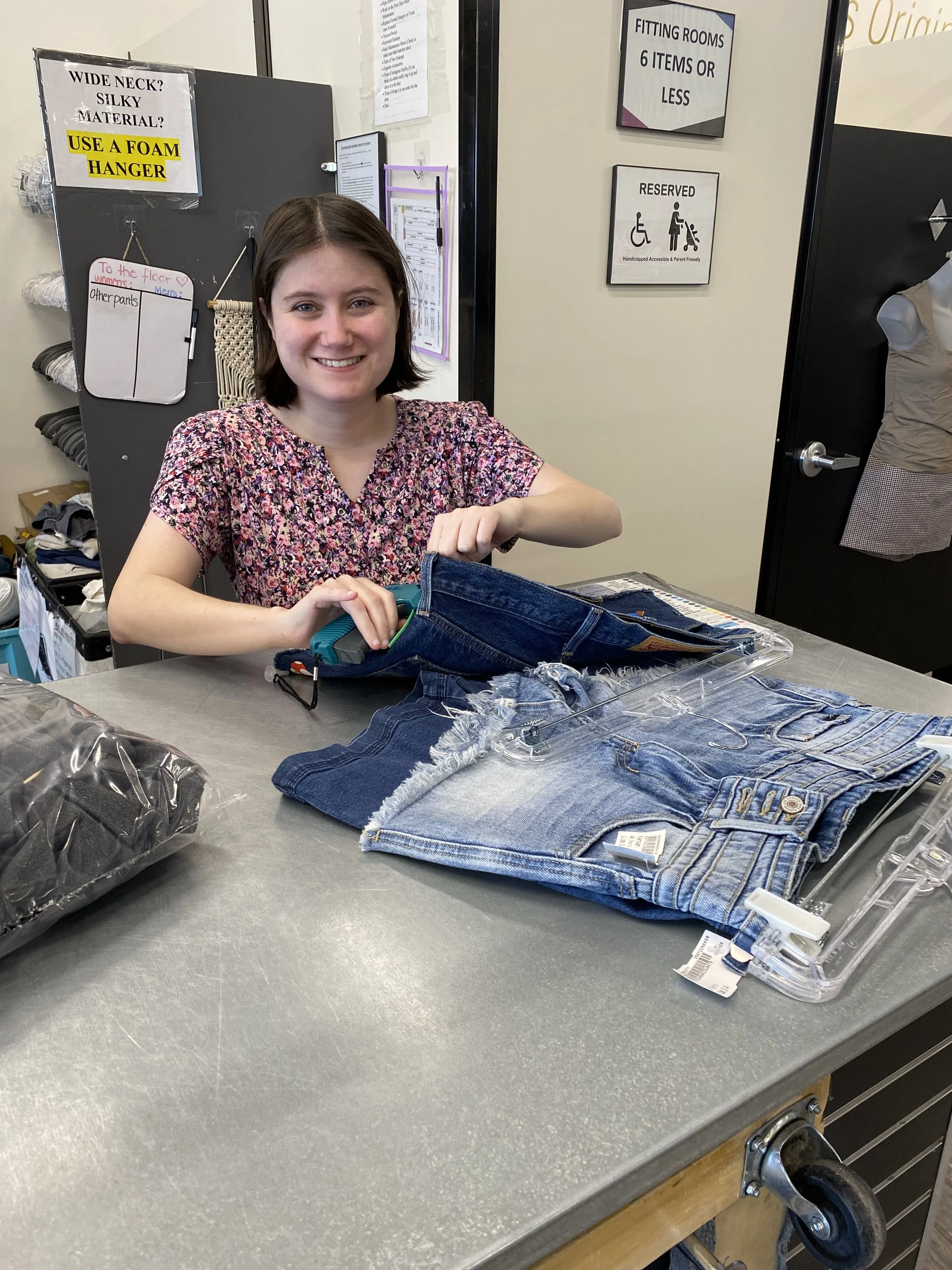 A young woman is shown tagging shorts. She has some shorts in front of her that she's already tagged.