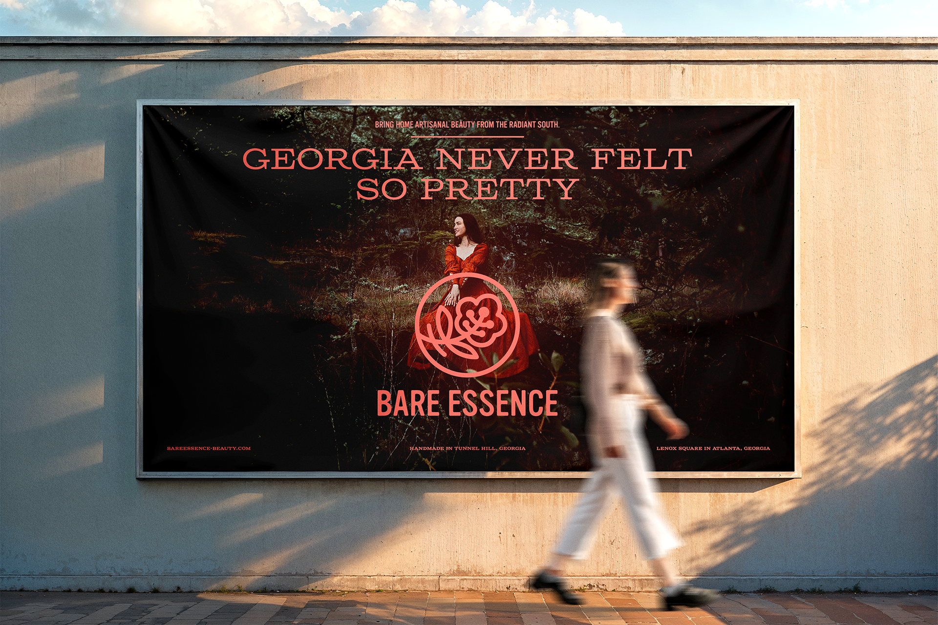 Street‑level billboard ad for Bare Essence featuring a woman seated in a southern forest setting, with bold centered typography and the primary logo.