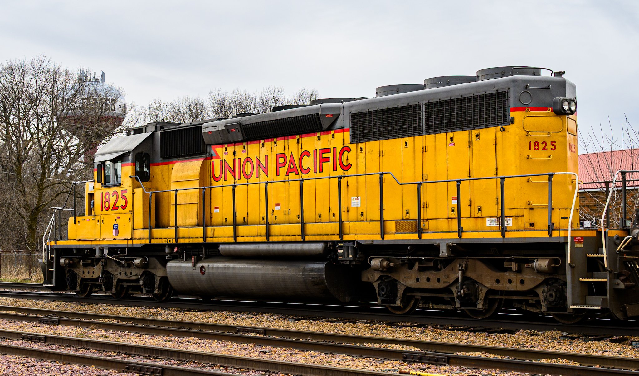A close side view of a yellow Union Pacific locomotive highlights the weathered metal, vents, and industrial details along the engine’s body.