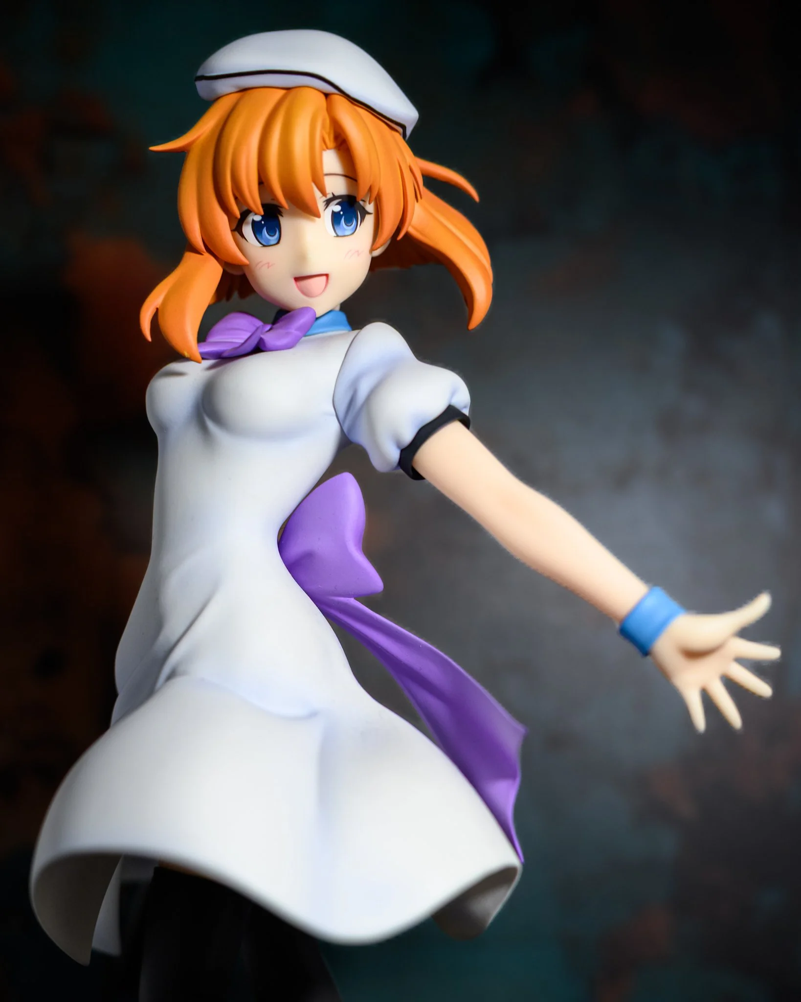 Anime-style figure of a red-haired girl in a flowing white dress, posed gracefully against a soft teal background with gentle studio lighting.