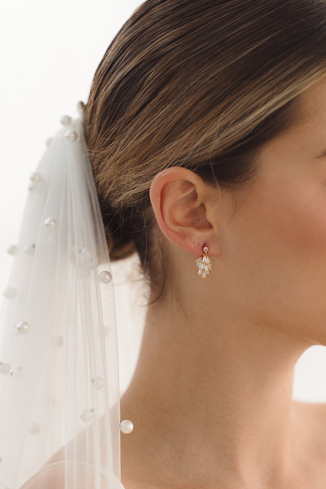 Modern bridal earrings and Jewelry for Minimal Classic Brides. Model wearing Bowie Earrings Studs with rhinestone details