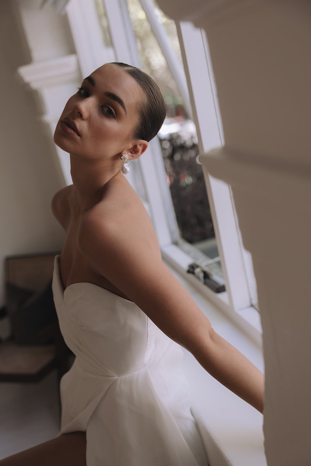 Modern wedding earrings and Jewelry for Minimal Brides. Model wearing Magnolia Earrings with rhinestone and pearl drops.