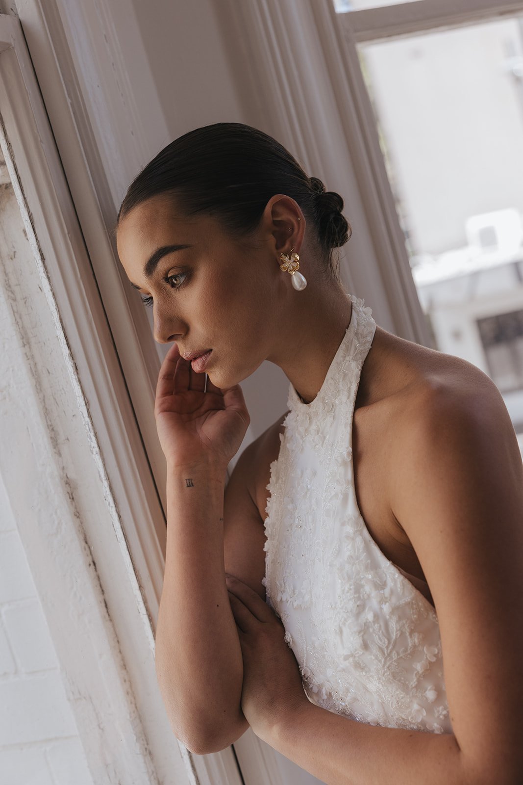 Modern bridal earrings and Jewelry for Minimal Classic Brides. Model wearing Ellery Earrings with rhinestone flowers and baroque pearls wedding earrings.